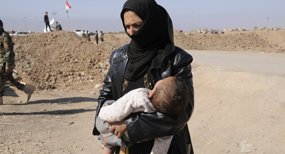 امرأة مع ابنها فارة من داعش في الانبار