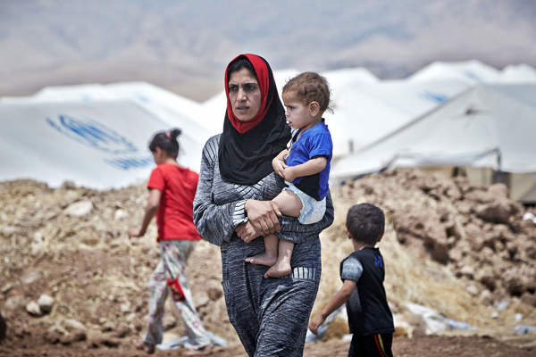 امراة نازحة مع اطفالها من الموصل