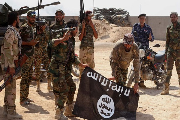 قوات عراقية يحملون راية داعش بعد مقتل العشرات منهم