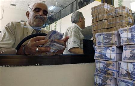 عميل يعد ماله عقب تسلمه من خزينة ببنك الرافدين في بغداد