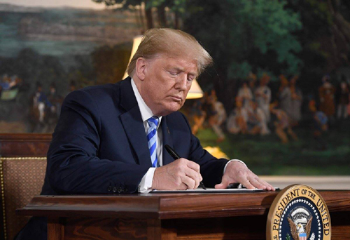 ترامب لحظة التوقيع على قرار الانسحاب من الاتفاق النووي 