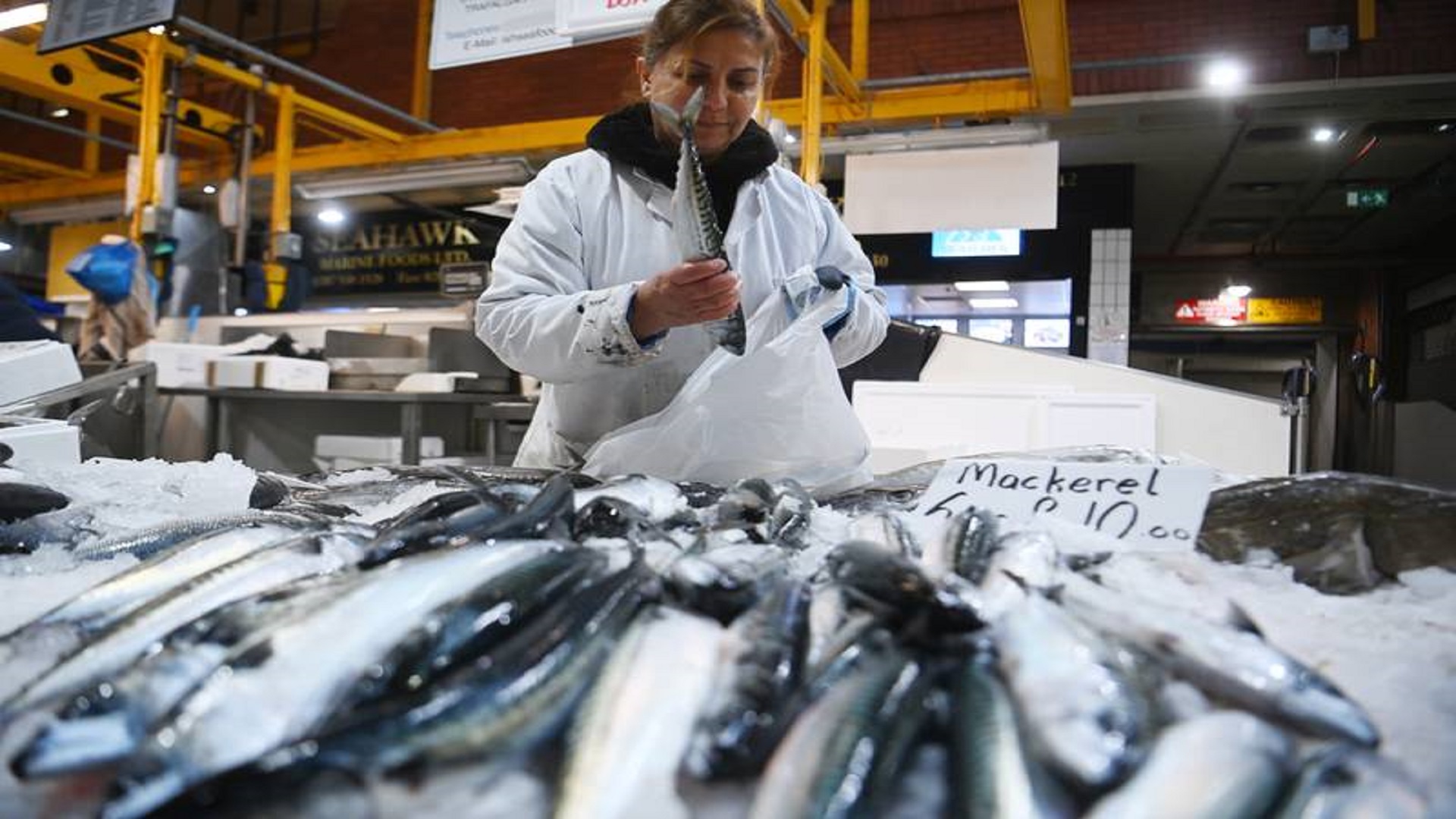 A worker adjusts her display at Billingsgate Fish Market in London. EPA