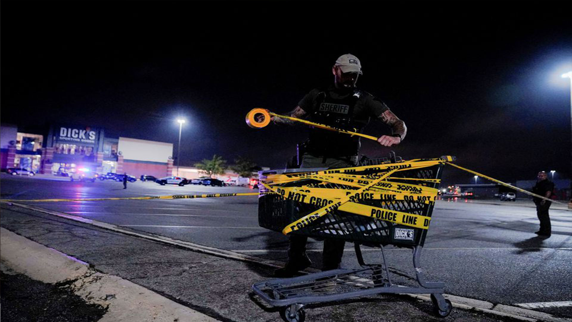  A law enforcement officer attaches a crime scene tape to a shopping cart after a shooting at a mall in the Indianapolis suburb of Greenwood, Indiana, U.S. July 17, 2022. REUTERS/Cheney Orr