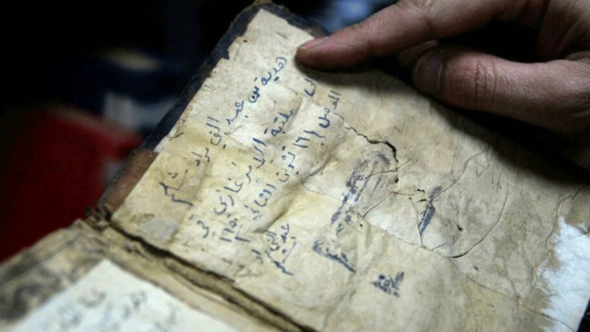  A librarian shows a book from University of Iraq's northern city of Mosul, one of those that escaped destruction at the hands of the ISIS group Zaid AL-OBEIDI AFP